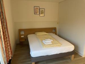 a bed in a bedroom with two towels on it at Medical Wellness RehaKlinik und Aqualon Therme in Bad Säckingen