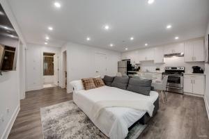 a living room with a couch and a kitchen at Modern 2Bed Suite Near Capilano Bridge & Trails in North Vancouver