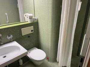 a bathroom with a white toilet and a sink at Medical Wellness RehaKlinik und Aqualon Therme in Bad Säckingen +21 photos