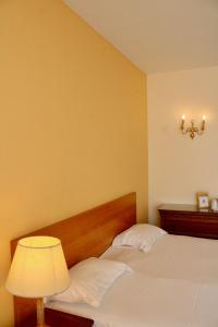 1 dormitorio con 1 cama con lámpara y luz en Hôtel de la Marine, en Saint-Herblain