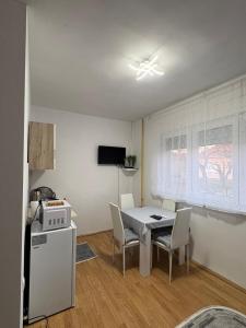 a kitchen and dining room with a table and chairs at Apartman Tijana in Ruma