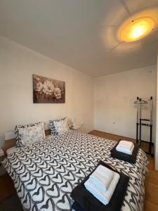 a bedroom with a bed with a black and white comforter at Apartman Tijana in Ruma