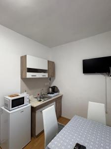 a small kitchen with a sink and a microwave at Apartman Tijana in Ruma