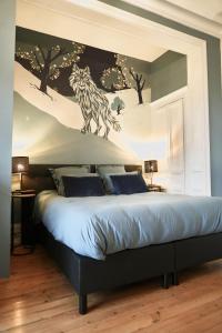 a bedroom with a bed with a mural of a wolf at Domaine des Monts de la Baie in Mareuil-Caubert