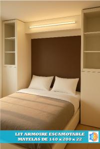 ein Bett mit weißen Kissen im Schlafzimmer in der Unterkunft CAMARG'Beach Vue mer-Piscines-Plages-Tennis-Parking-4PERS in Le Grau-du-Roi + 22 Fotos