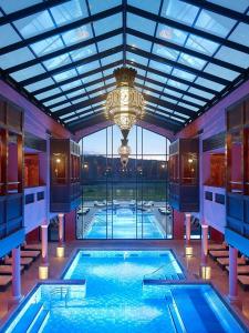 una gran piscina con una lámpara de araña en un edificio en Sarre-Ulysse Refined apartment in Sarreguemines, en Sarreguemines