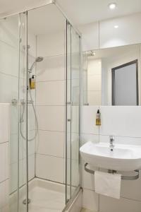 a bathroom with a sink and a glass shower at Hotel Restaurant Isidore by Soniho in Nice +39 photos