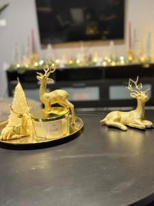 three gold statues of deer and a christmas tree on a table at RHODESIA guest house in Chalkida