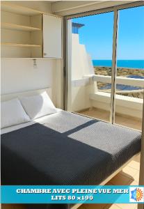 ein Schlafzimmer mit einem Bett und Meerblick in der Unterkunft CAMARG'Beach Vue mer-Piscines-Plages-Tennis-Parking-4PERS in Le Grau-du-Roi