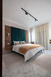 Mondo suites apparts lac 2 Tunis في حلق الوادي: غرفة نوم بسرير كبير وبجدار اخضر
