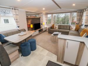 a living room with a couch and a table at Woodland View in Skipton