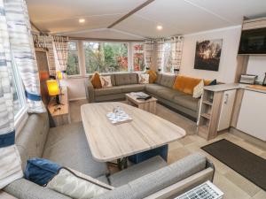 a living room with a couch and a table at Woodland View in Skipton