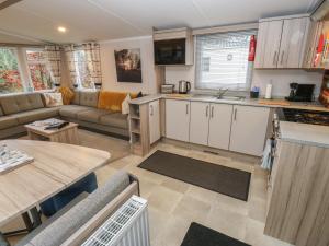 a kitchen and living room with a couch and a table at Woodland View in Skipton +6 photos