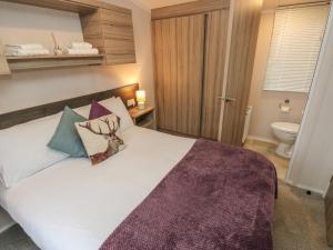 a bedroom with a large white bed with pillows at Woodland View in Skipton
