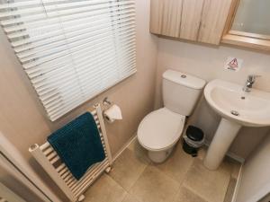 a small bathroom with a toilet and a sink at Woodland View in Skipton
