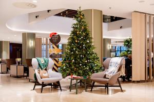 a christmas tree in the lobby of a store at Crowne Plaza Bratislava by IHG in Bratislava