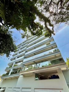 ein hohes weißes Wohnhaus mit Fenstern in der Unterkunft Dubai Thermas Piratuba 406 in Piratuba