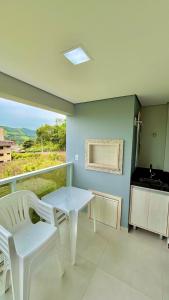 einen weißen Tisch und zwei weiße Stühle in einem Zimmer in der Unterkunft Dubai Thermas Piratuba 406 in Piratuba