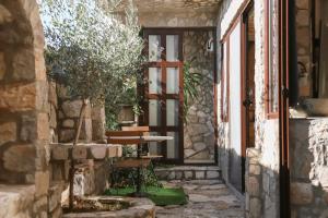 un ingresso di una casa in pietra con una porta e una panchina di Mahakala Center a Petrovac na Moru