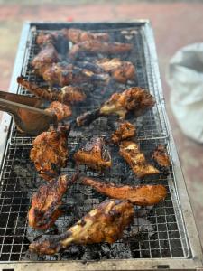 een grill met kippenvleugels en ander eten erop bij Jaffna Stay Guest House in Jaffna