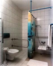 a bathroom with a toilet and a shower stall at Hotel garni Zur Mühle in Angermünde