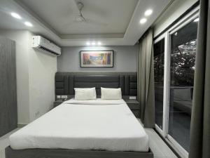 a bedroom with a large white bed and a window at LR Suites Near Huda City Centre in Gurgaon