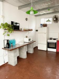 a kitchen with a table and a white refrigerator at Morada del Sol in San Bernardo