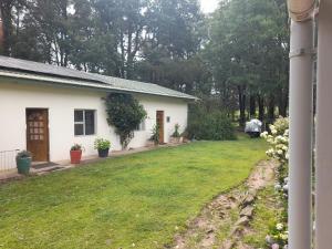 a small white house with a yard at Do-Little Cottages in Port Edward