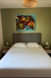 een bed in een slaapkamer met een schilderij aan de muur bij Résidence Luna, Saint-Cyprien in Porto-Vecchio