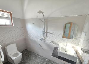 Aruna homestay في بولوناروا: حمام أبيض مع مرحاض ومغسلة +14 صورة