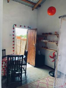 ein Zimmer mit einem Tisch, einem Stuhl und einer Tür in der Unterkunft Chipatso in Cape Maclear + 22 Fotos