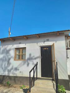 ein kleines weißes Haus mit einer schwarzen Tür in der Unterkunft Chipatso in Cape Maclear