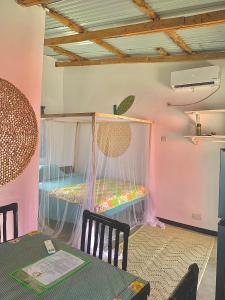 ein Zimmer mit einem Tisch und einem Bett mit Moskitonetzen in der Unterkunft Chipatso in Cape Maclear