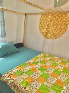 ein Bett in einem Zelt mit einer Decke darauf in der Unterkunft Chipatso in Cape Maclear