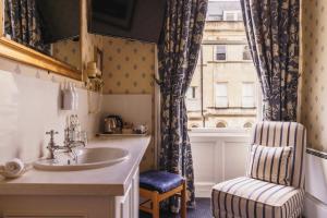uma casa de banho com um lavatório, uma cadeira e uma janela em The Kennard em Bath mais 111 fotografias