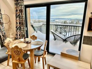 a dining room with a table and a balcony at Domek Tatry - Stacja Wierchowa 972 m in Brzegi