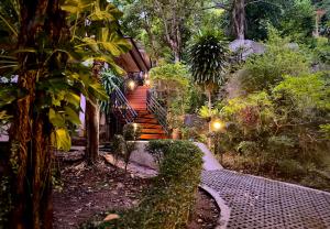 a set of wooden stairs in a garden with trees at PawPaw Resort in Lamai