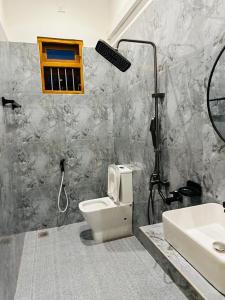 Un baño con inodoro, ducha y lavabo. en Omar Villa, en Bentota
