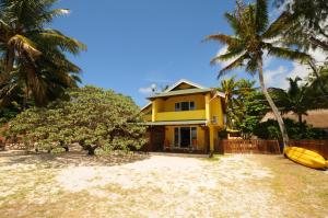 a yellow house with a surfboard in front of it at Villa Easternwind in Pointe d'Esny