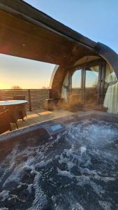 un jacuzzi en la terraza de una casa en Pepperwood Pods, en Worlaby