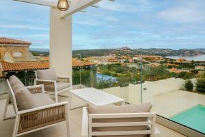 a balcony with chairs and a view of a city at Smeraldo Apartment in Palau