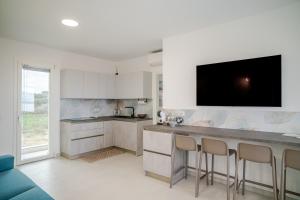 a kitchen with a counter and a tv on the wall at Smeraldo Apartment in Palau