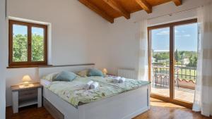 una camera da letto con un letto e un balcone di Rustic villa Marijanin Vrt with pool in Tinjan a Tinjan Altre 32 foto