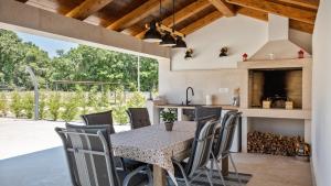 una cucina aperta e una sala da pranzo con tavolo e sedie di Rustic villa Marijanin Vrt with pool in Tinjan a Tinjan