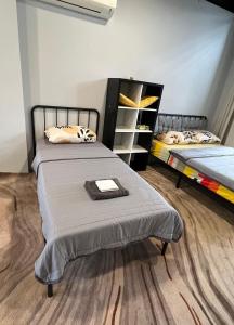a bedroom with two beds and a book shelf at Lumi Tropicana - Unique Stays ! in Kota Damansara +47 photos