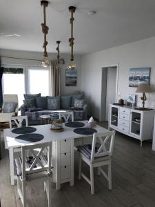 a living room with a table and a couch at Strandhaus - Appartment Seeschwalbe in Fehmarnsund +19 photos