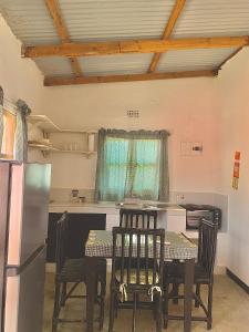 eine Küche mit Tisch und Stühlen und einem Kühlschrank in der Unterkunft Chipatso in Cape Maclear + 27 Fotos