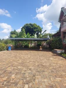 Un pabellón con un dosel negro en un patio. en Yukis & Kukis Place 5 Bedrooms, en Embu