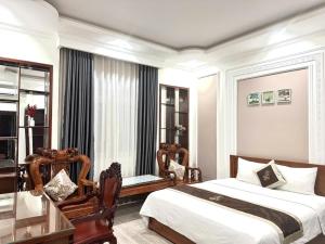 a bedroom with a bed and a table and chairs at Lucasta Hotel in Can Tho