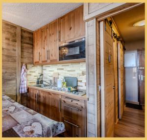 a kitchen with wooden cabinets and a counter top at L'Alpenlake I Studio I Châtel in Châtel